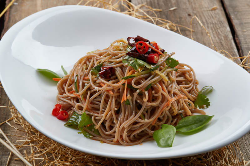 白色瓷盘装的的香辣荞麦凉面图片