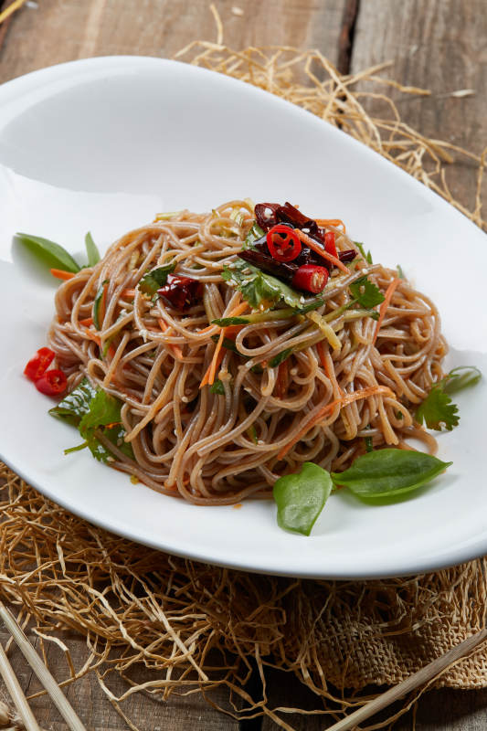 白色瓷盘装的的香辣荞麦凉面图片