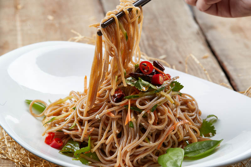 白色瓷盘装的的香辣荞麦凉面图片