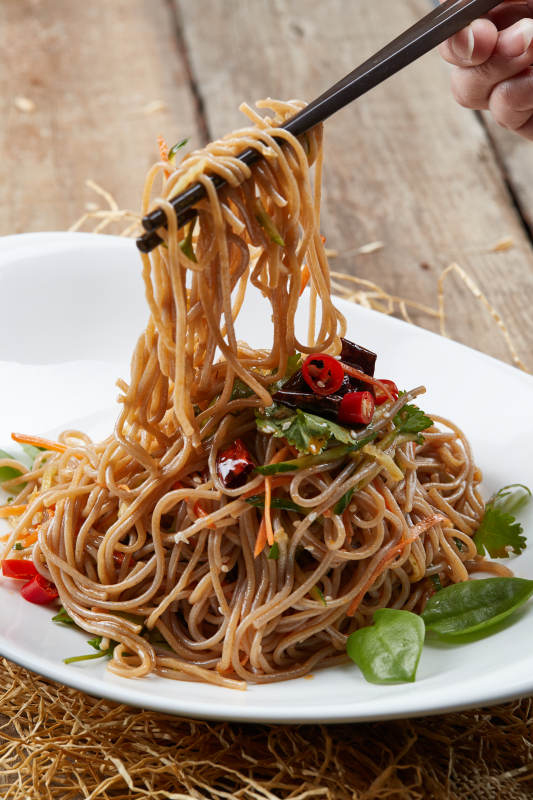 白色瓷盘装的的香辣荞麦凉面图片