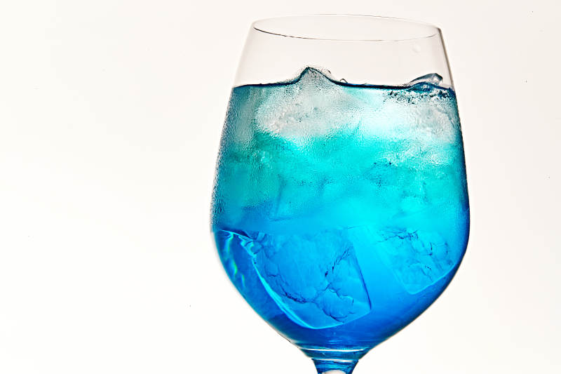 酒杯中的清凉蓝橙汁百加得调制的鸡尾酒图片