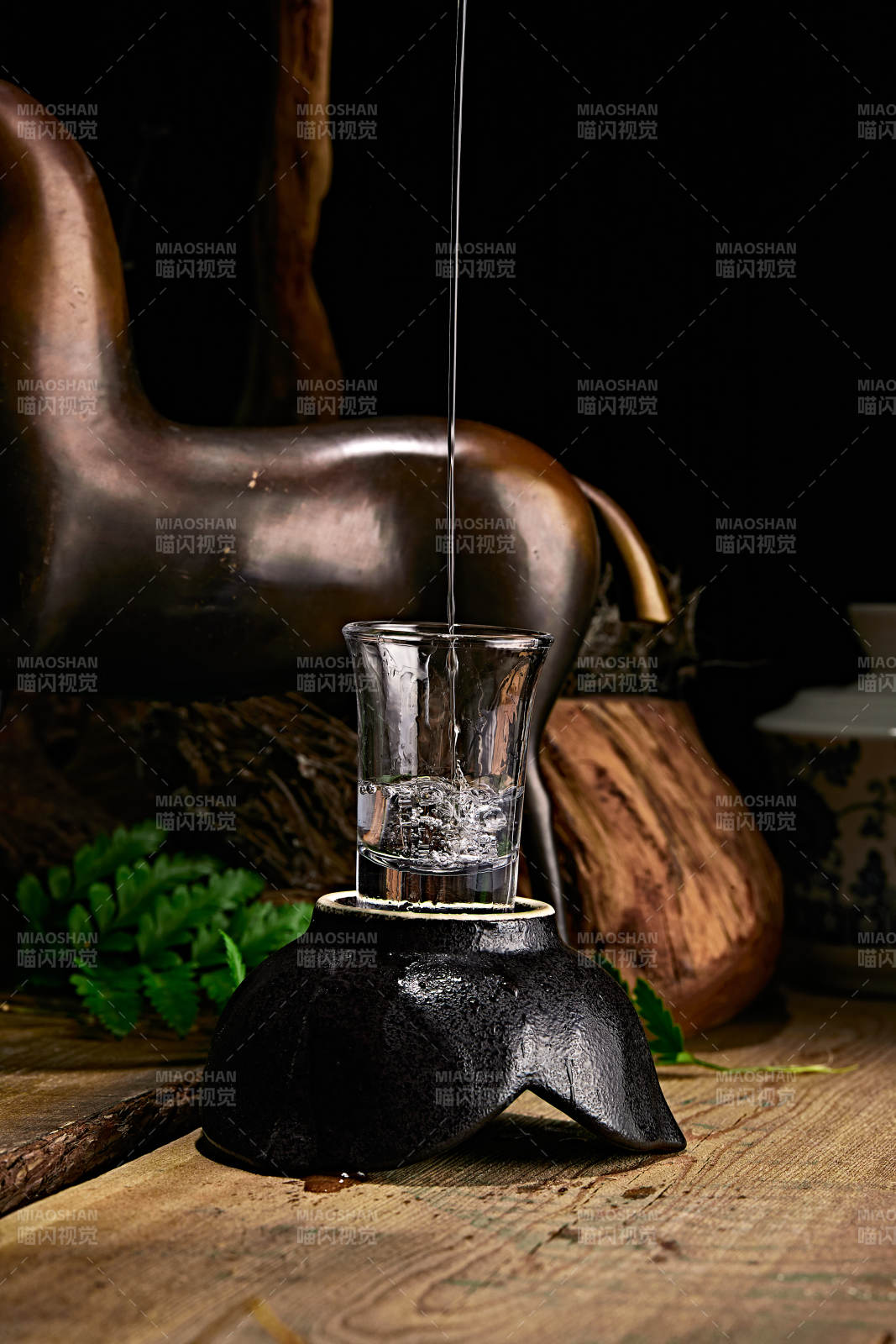 木板上摆放的酒具倒入清澈的白酒激起酒花图片