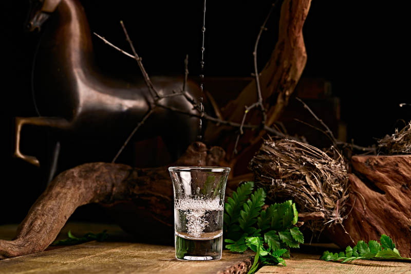 木板上摆放的酒具倒入清澈的白酒激起酒花图片