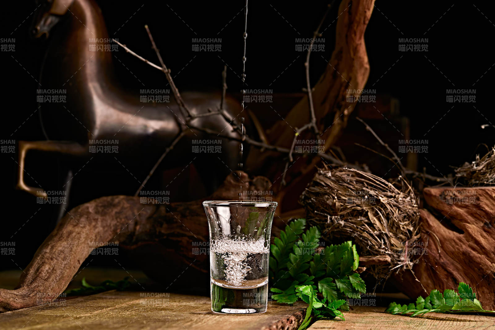 木板上摆放的酒具倒入清澈的白酒激起酒花图片