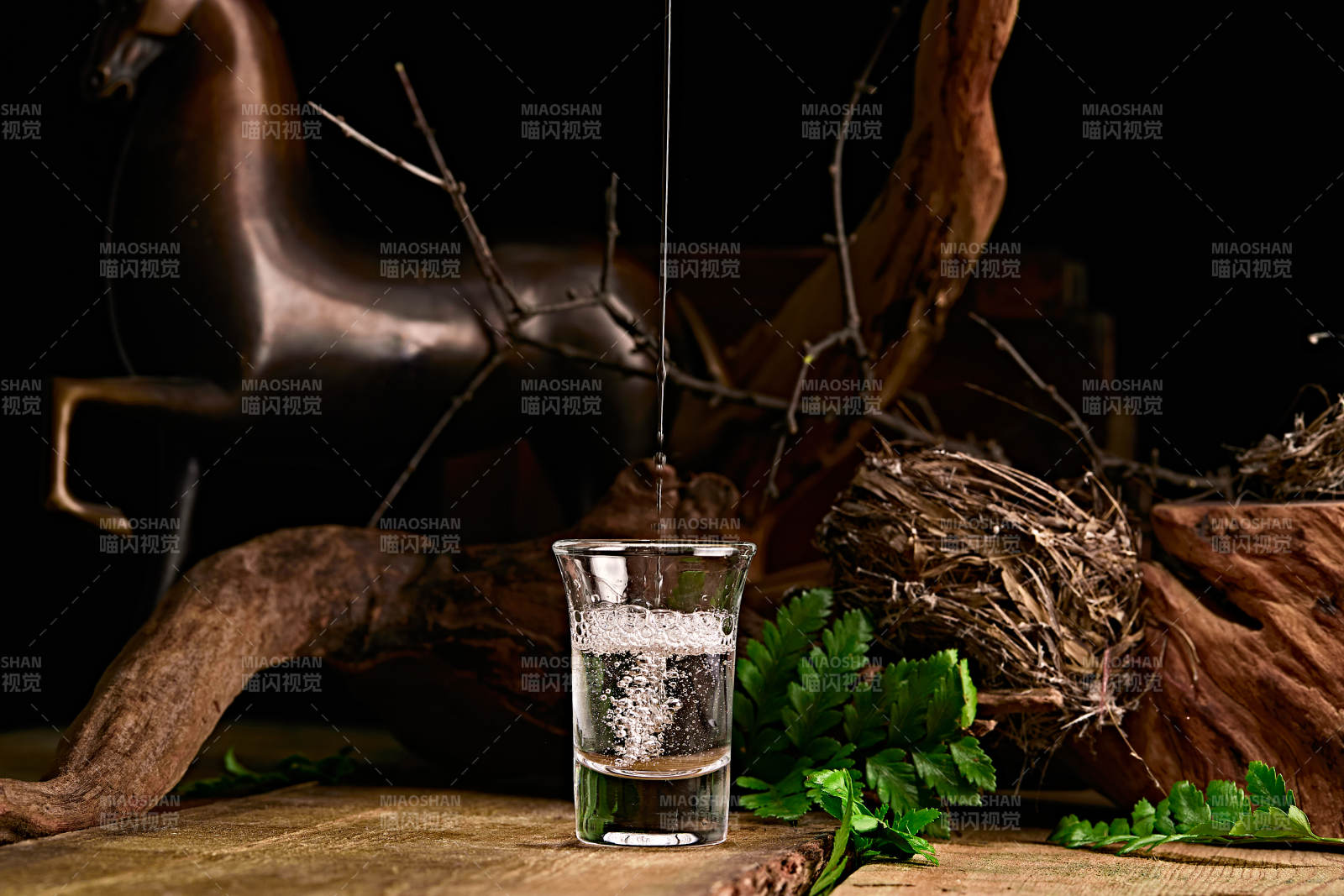 木板上摆放的酒具倒入清澈的白酒激起酒花图片