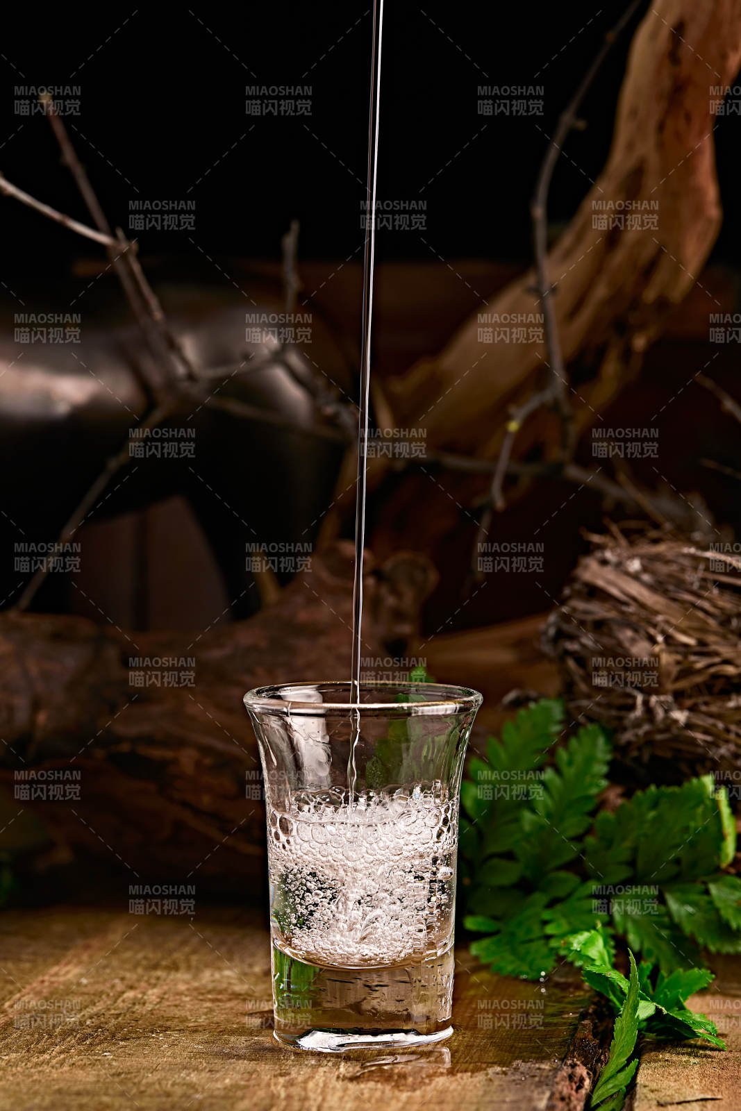 木板上摆放的酒具倒入清澈的白酒激起酒花图片