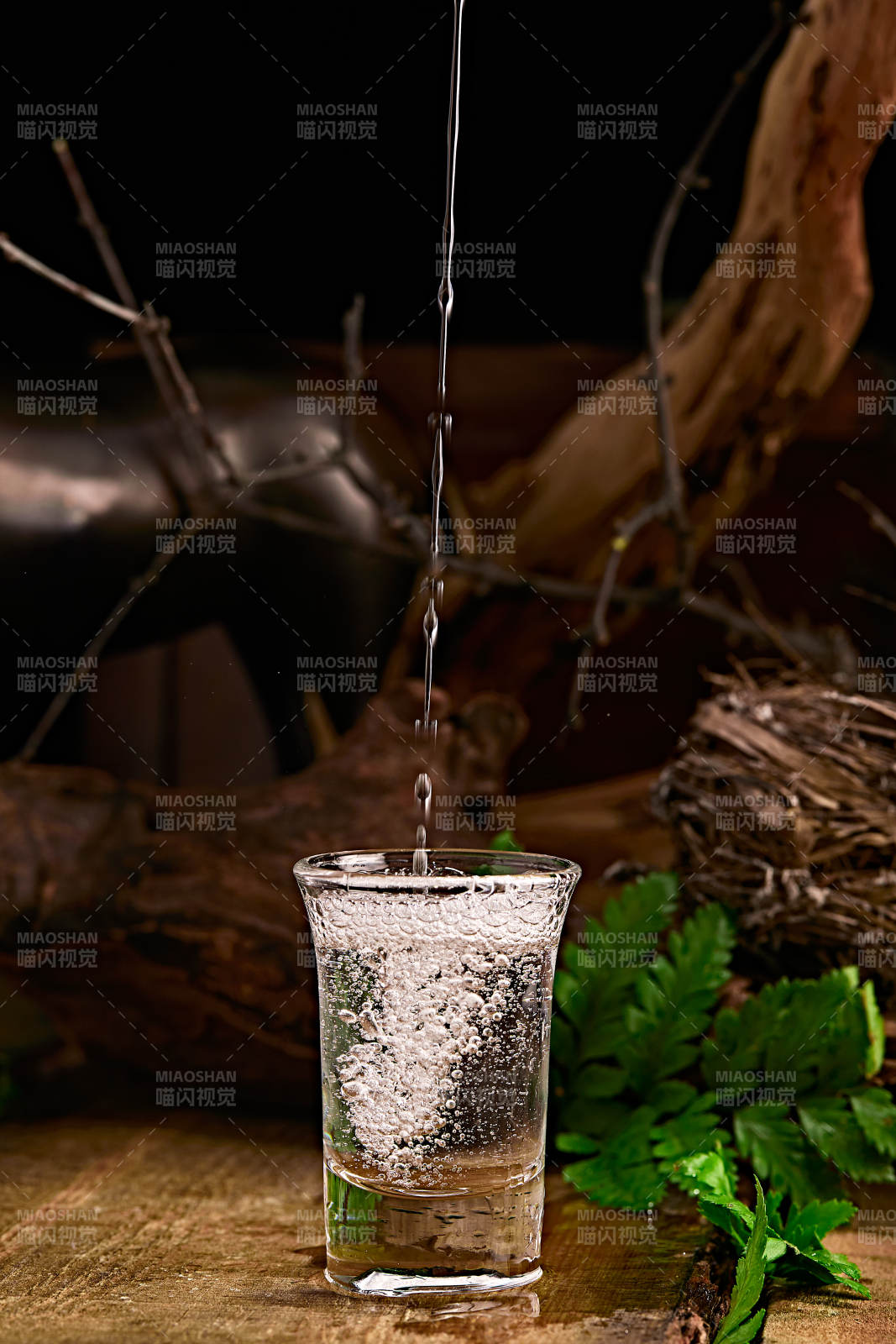 木板上摆放的酒具倒入清澈的白酒激起酒花图片