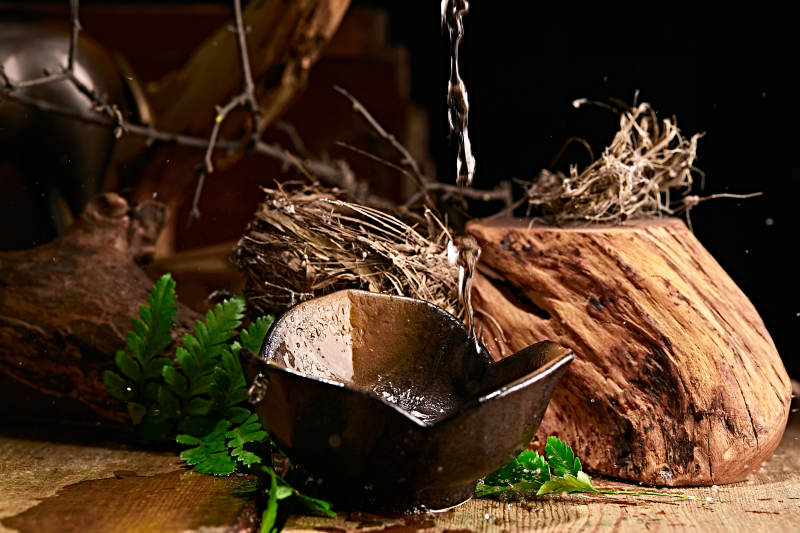 木板上摆放的酒具倒入清澈的白酒激起酒花图片