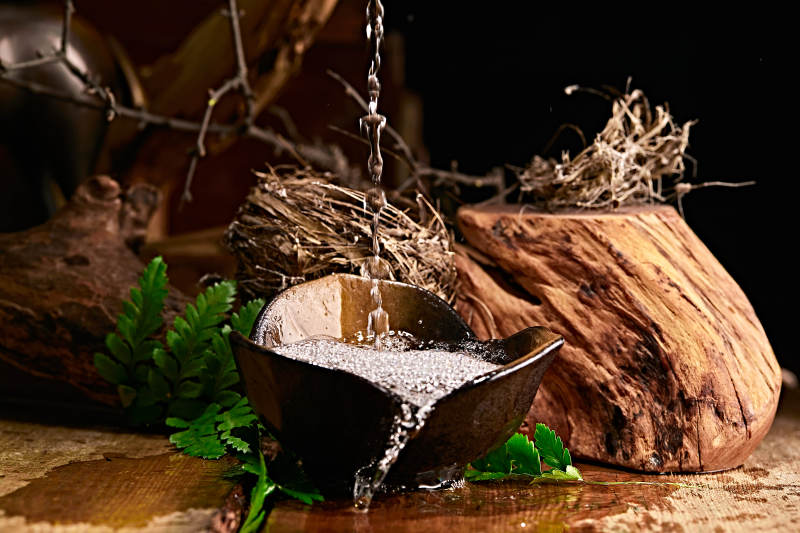 木板上摆放的酒具倒入清澈的白酒激起酒花图片