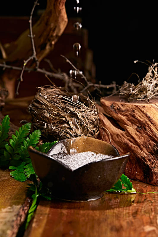 木板上摆放的酒具倒入清澈的白酒激起酒花图片