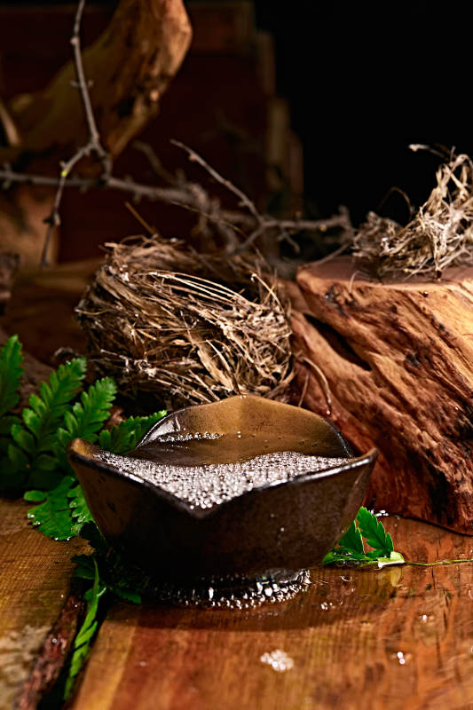 木板上摆放的酒具倒入清澈的白酒激起酒花图片