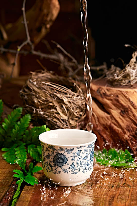 木板上摆放的酒具倒入清澈的白酒激起酒花图片