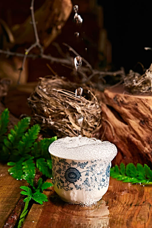 木板上摆放的酒具倒入清澈的白酒激起酒花图片