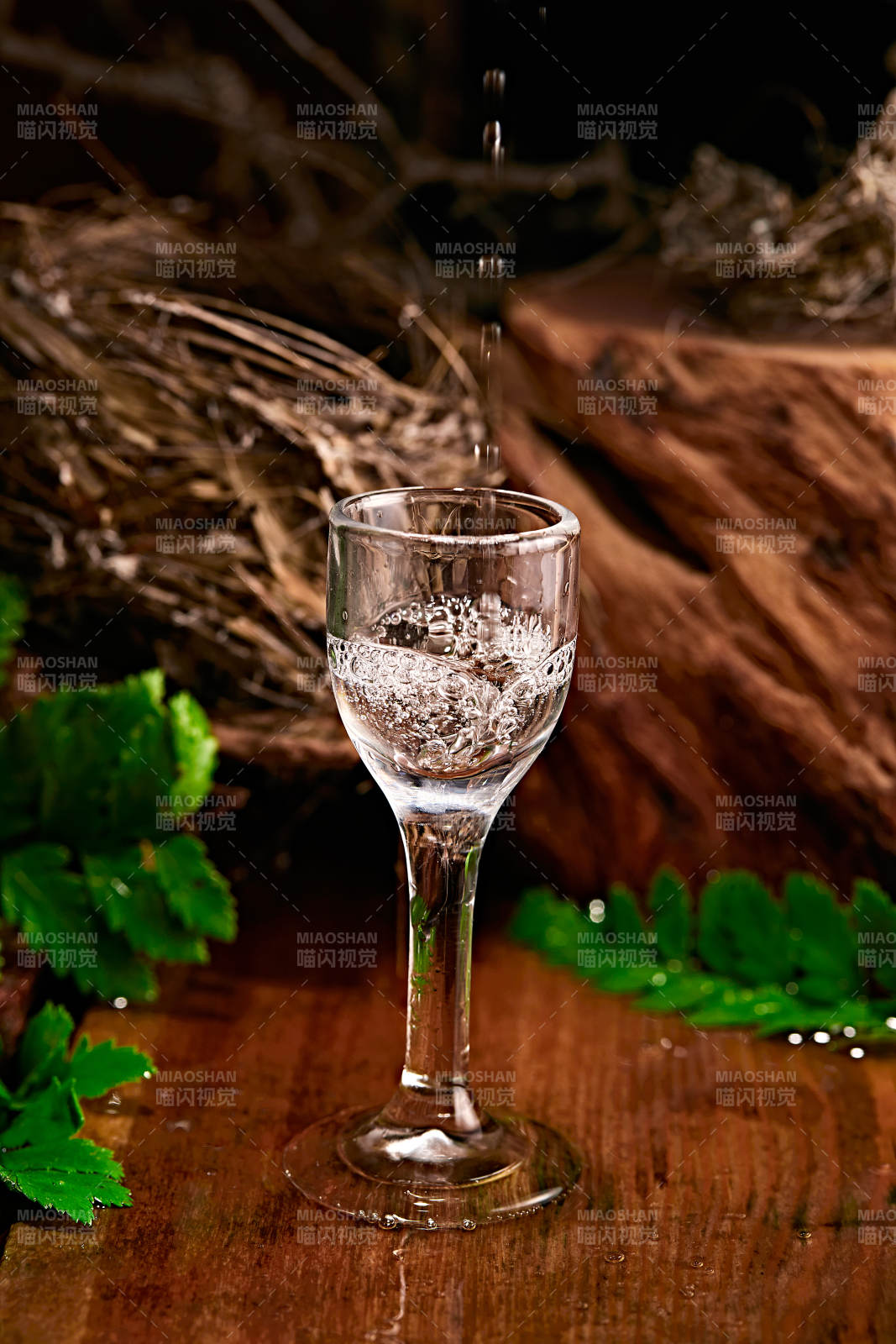 木板上摆放的酒具倒入清澈的白酒激起酒花图片