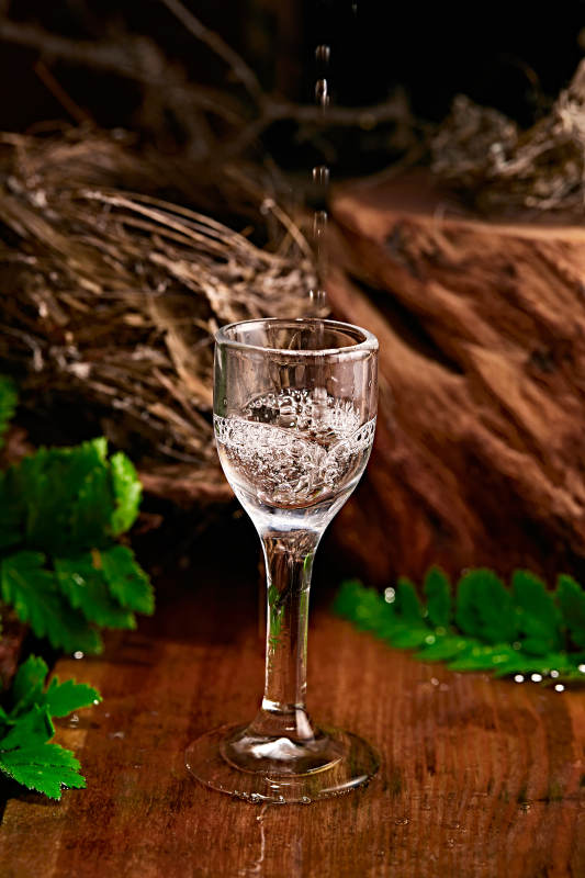 木板上摆放的酒具倒入清澈的白酒激起酒花图片