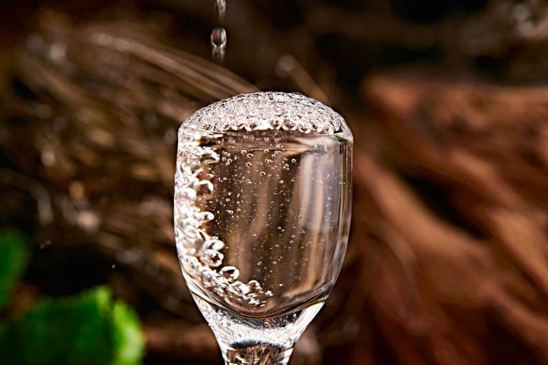 木板上摆放的酒具倒入清澈的白酒激起酒花图片