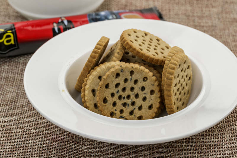 白色瓷盘装的营养健康燕麦全麦曲奇饼干图片