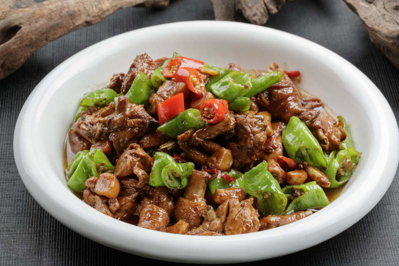 白色瓷盘装的双色螺丝椒炒三黄鸡块图片