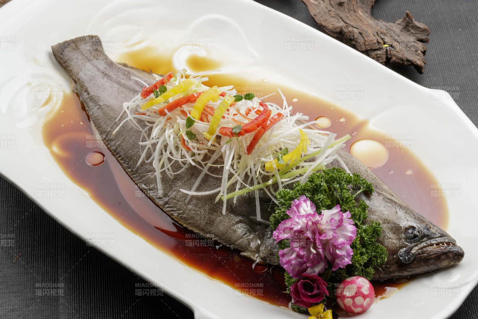 白色瓷盘装的浇汁清蒸海鲈鱼图片