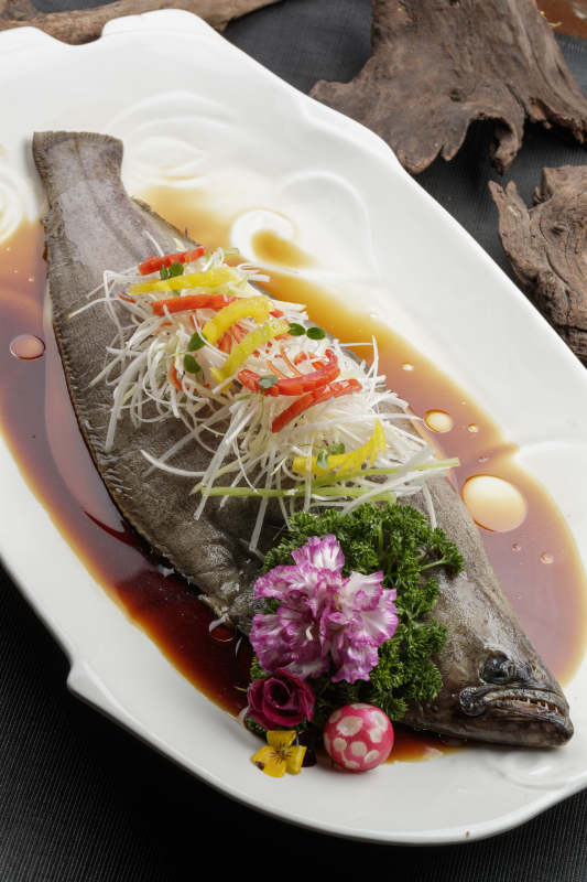 白色瓷盘装的浇汁清蒸海鲈鱼图片