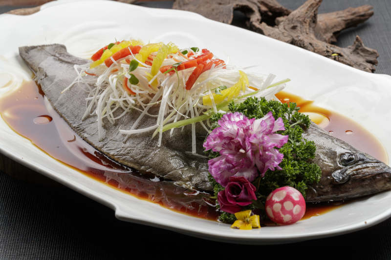 白色瓷盘装的浇汁清蒸海鲈鱼图片