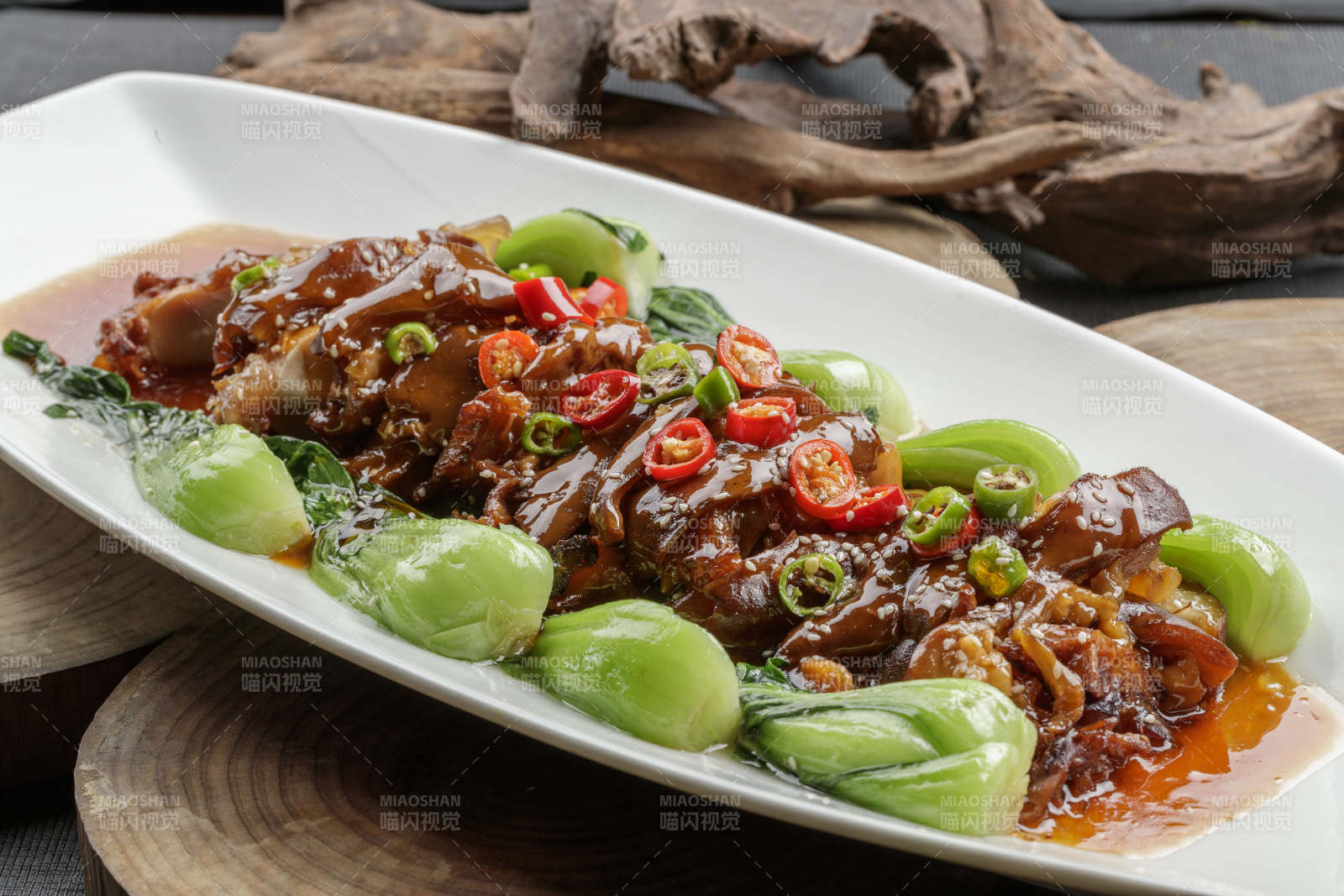 白色瓷盘装的香辣红烧大肘子肉图片