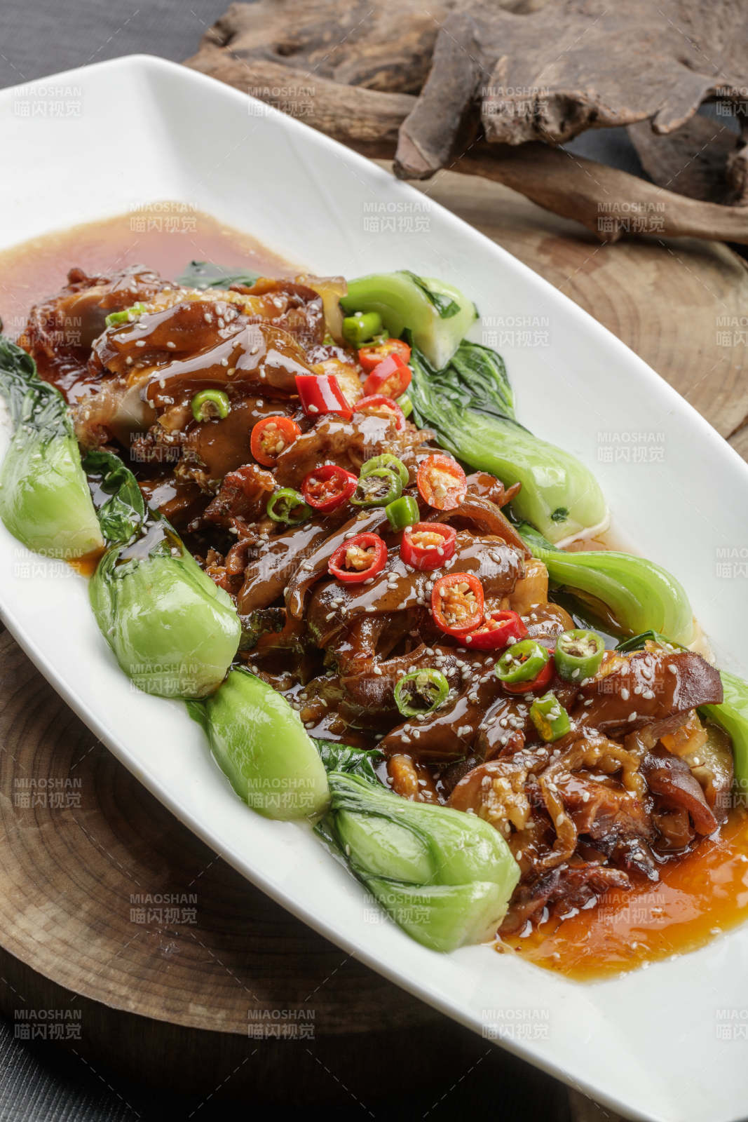 白色瓷盘装的香辣红烧大肘子肉图片