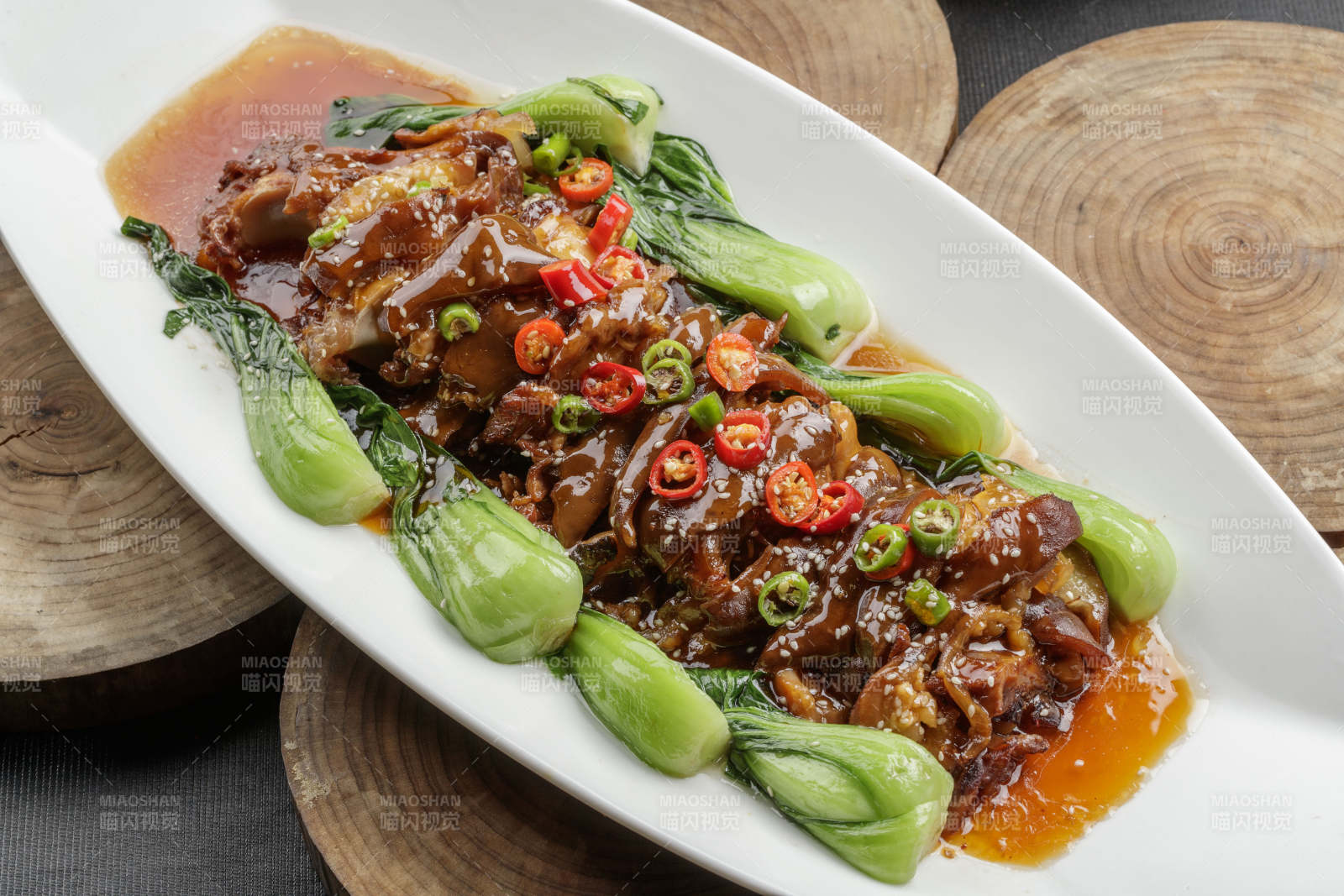 白色瓷盘装的香辣红烧大肘子肉图片