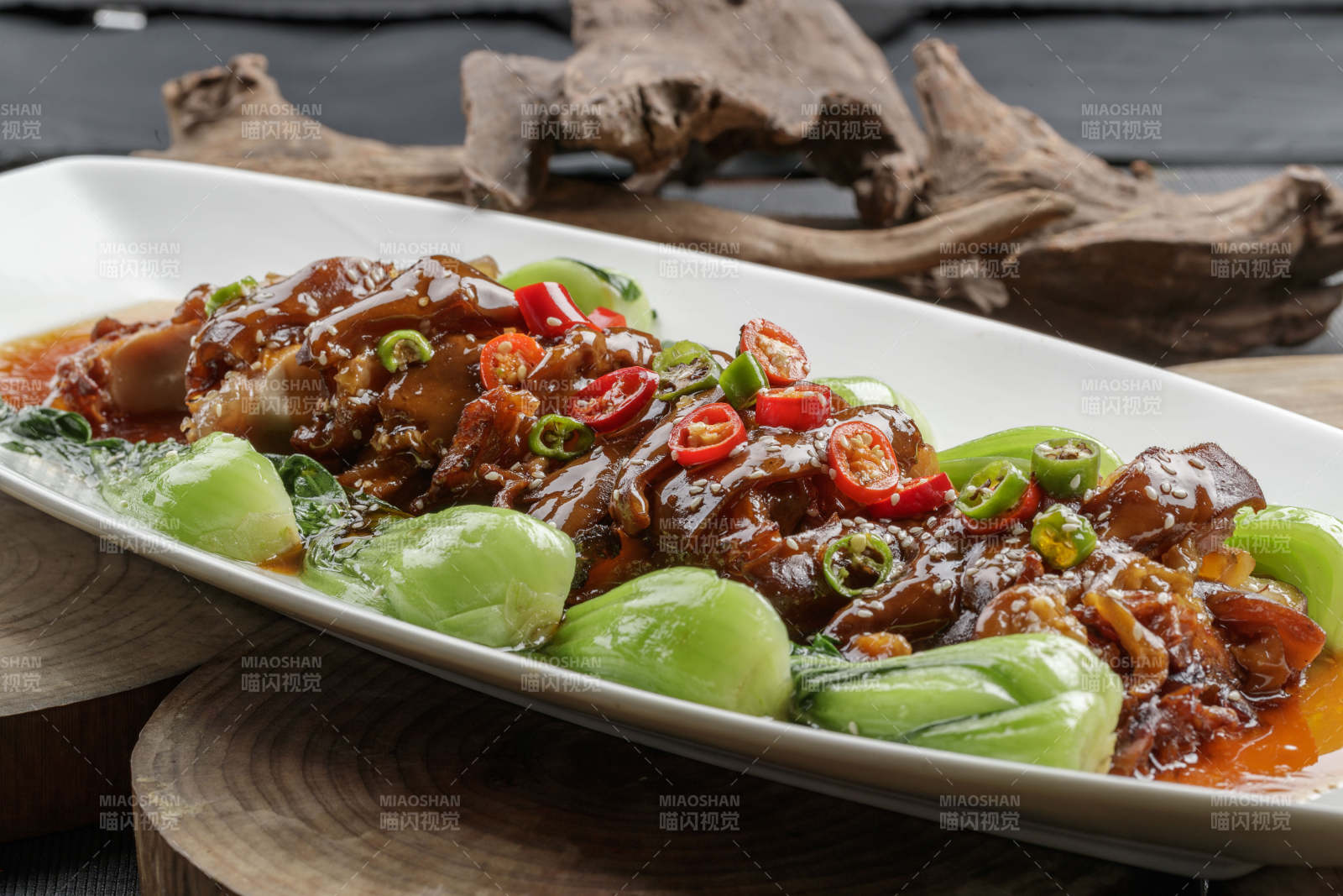 白色瓷盘装的香辣红烧大肘子肉图片