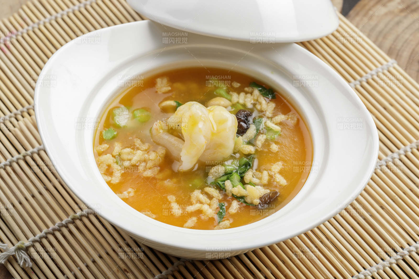 白色瓷餐具装的鱼翅虾仁海鲜浓汤图片