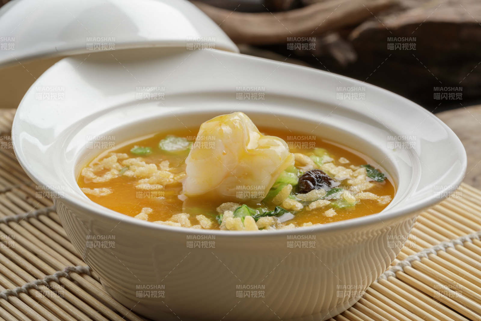 白色瓷餐具装的鱼翅虾仁海鲜浓汤图片