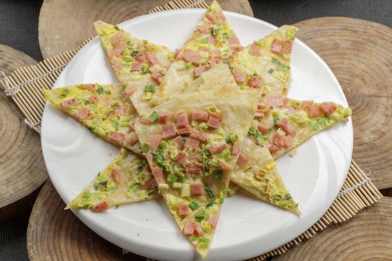 白色瓷盘装的蔬菜熏肉烙饼图片