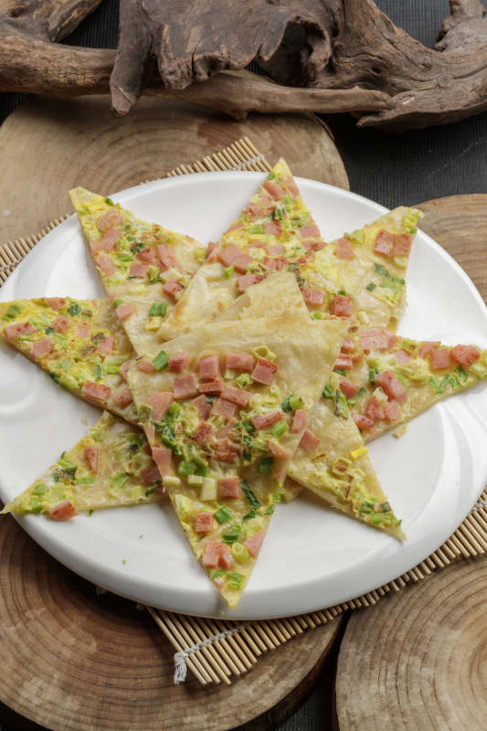 白色瓷盘装的蔬菜熏肉烙饼图片