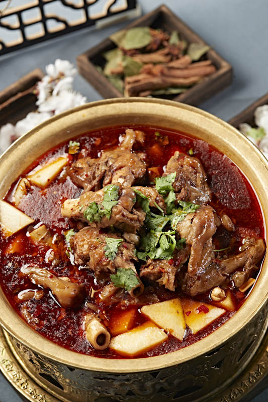 铜锅炖煮的红油香辣羊棒骨羊膝骨图片