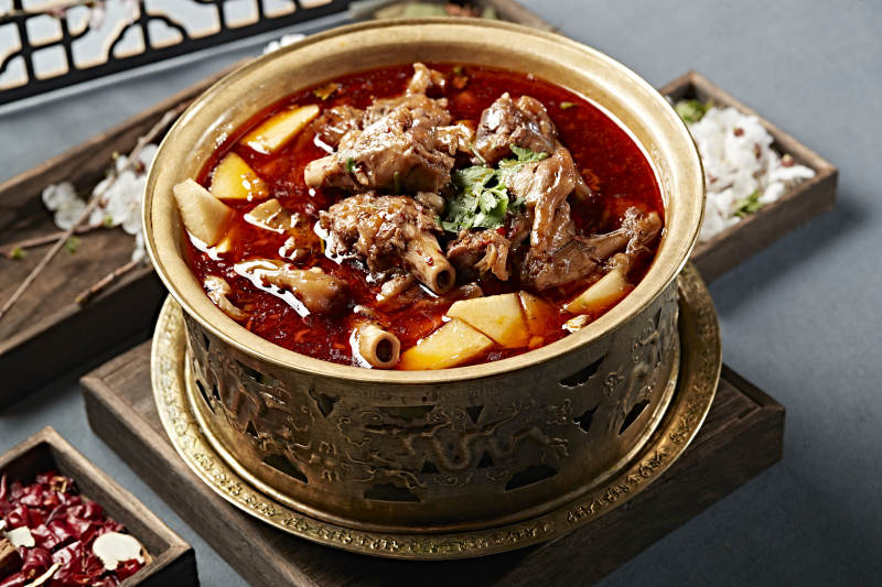 铜锅炖煮的红油香辣羊棒骨羊膝骨图片