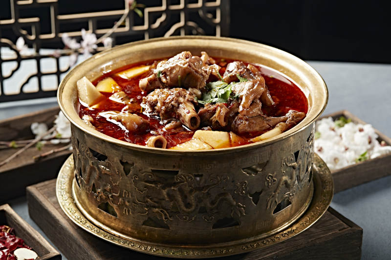 铜锅炖煮的红油香辣羊棒骨羊膝骨图片