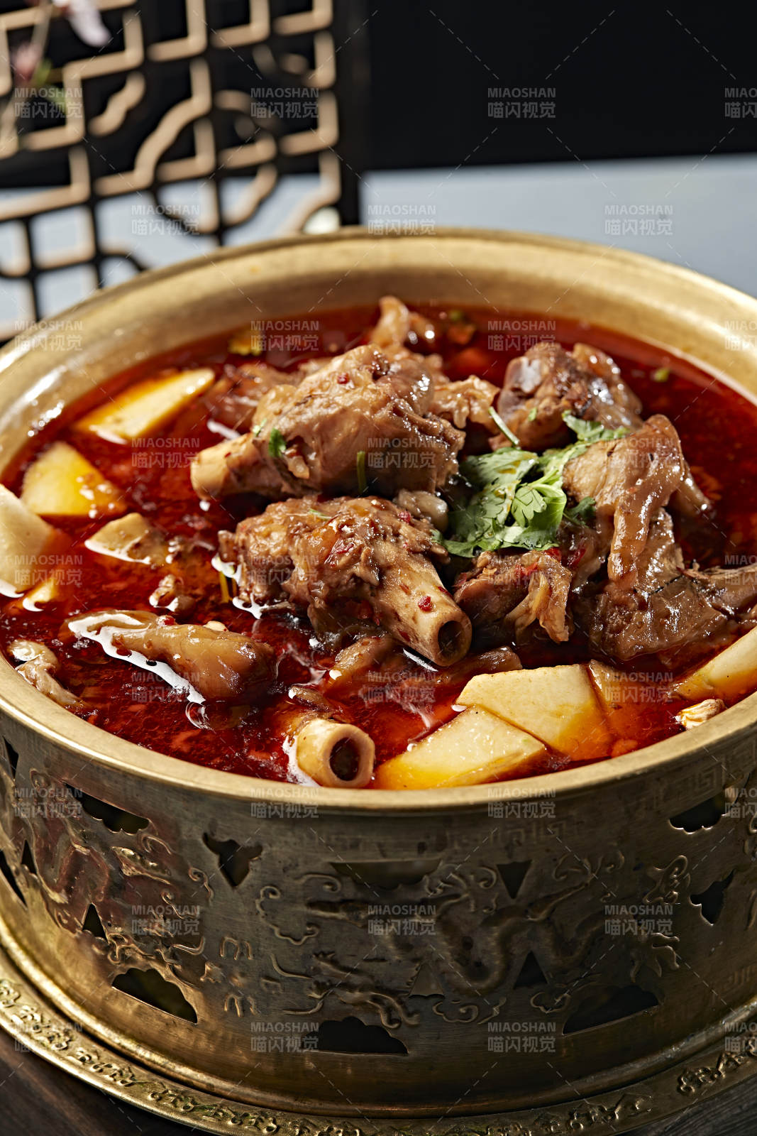 铜锅炖煮的红油香辣羊棒骨羊膝骨图片
