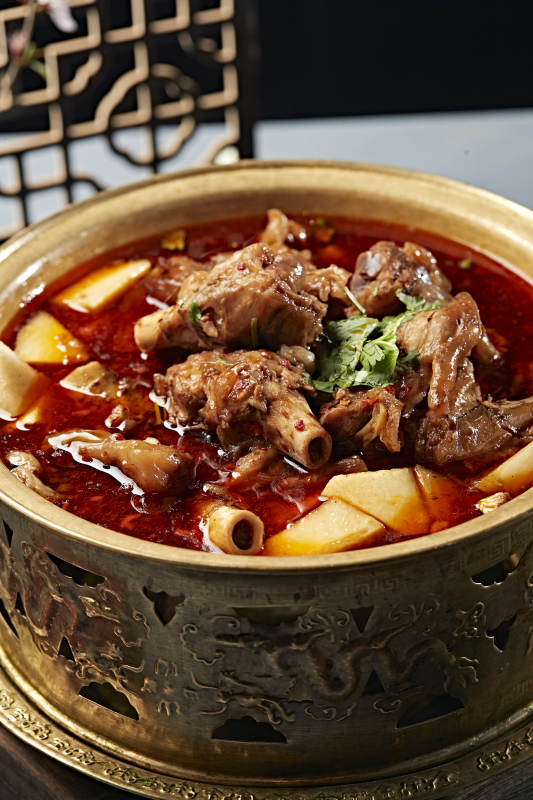 铜锅炖煮的红油香辣羊棒骨羊膝骨图片