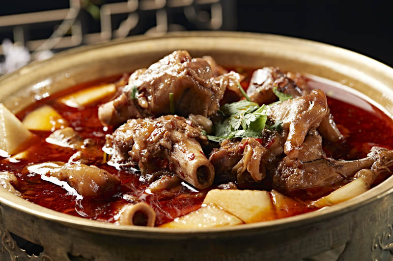 铜锅炖煮的红油香辣羊棒骨羊膝骨图片