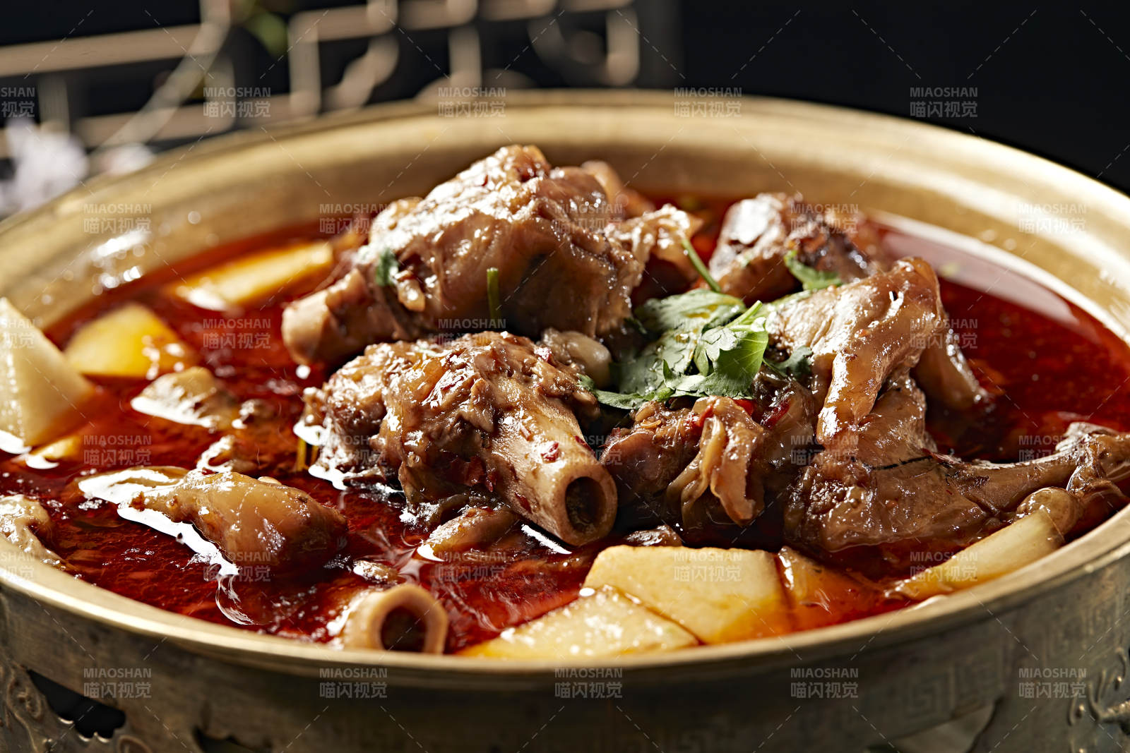 铜锅炖煮的红油香辣羊棒骨羊膝骨图片