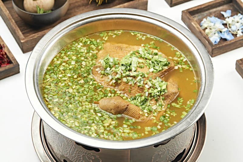 铜锅餐具装的葱香炖煮柴鸡汤图片