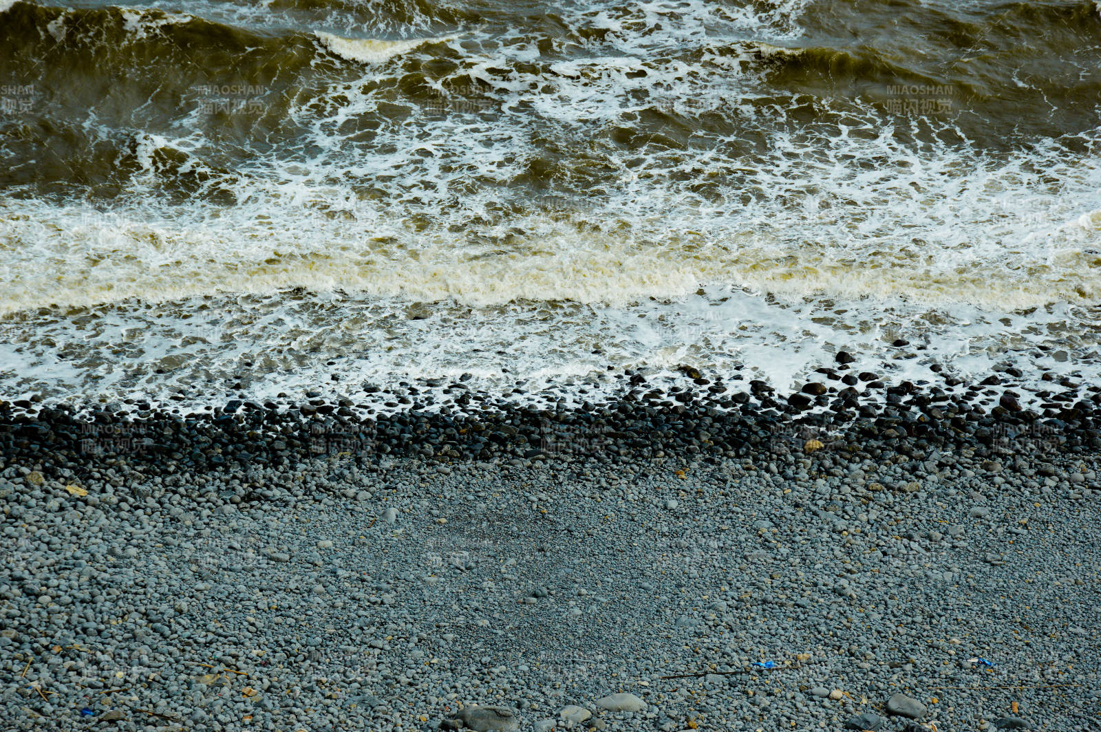 浪花拍打鹅卵石滩图片