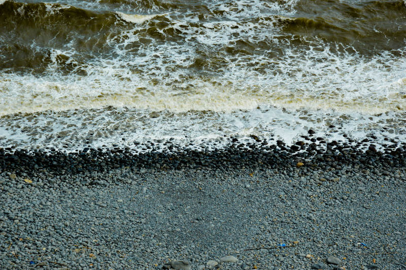 浪花拍打鹅卵石滩图片