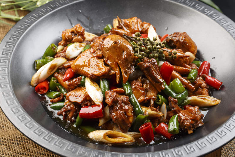 白色瓷盘装的辣炒香芹雪菜猪肚丝图片