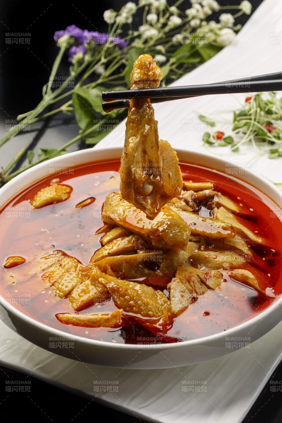 扇形瓷盘摆放的白瓷碗装的麻辣口水鸡图片