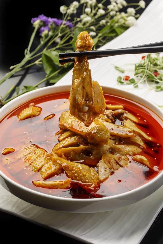 扇形瓷盘摆放的白瓷碗装的麻辣口水鸡图片