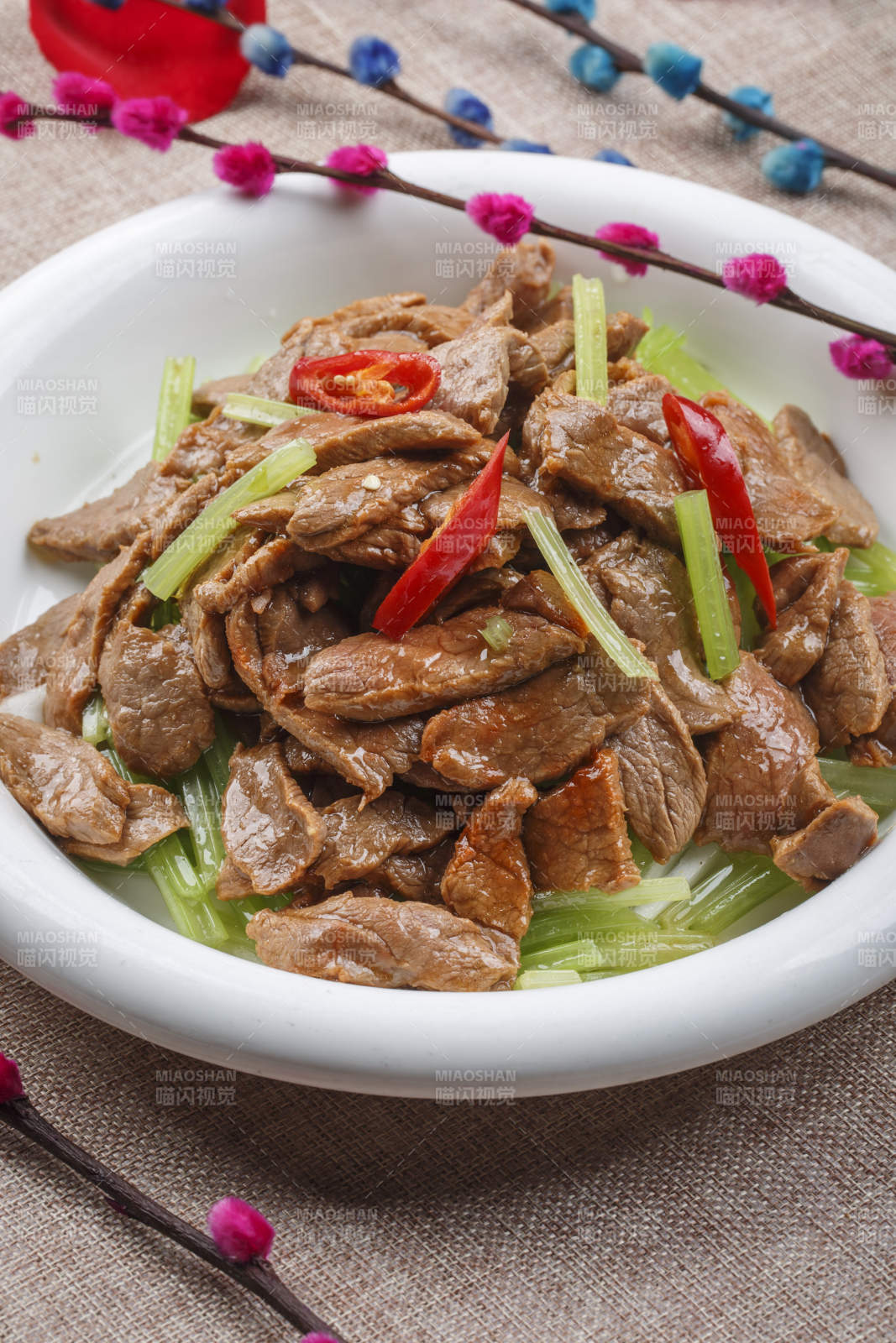 白色圆形瓷盘装的尖椒炒五花肉图片