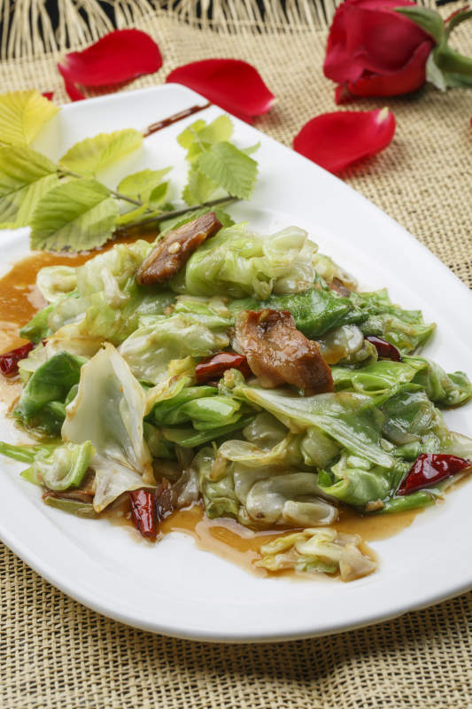 白色圆形瓷盘装的大葱爆羊肉图片