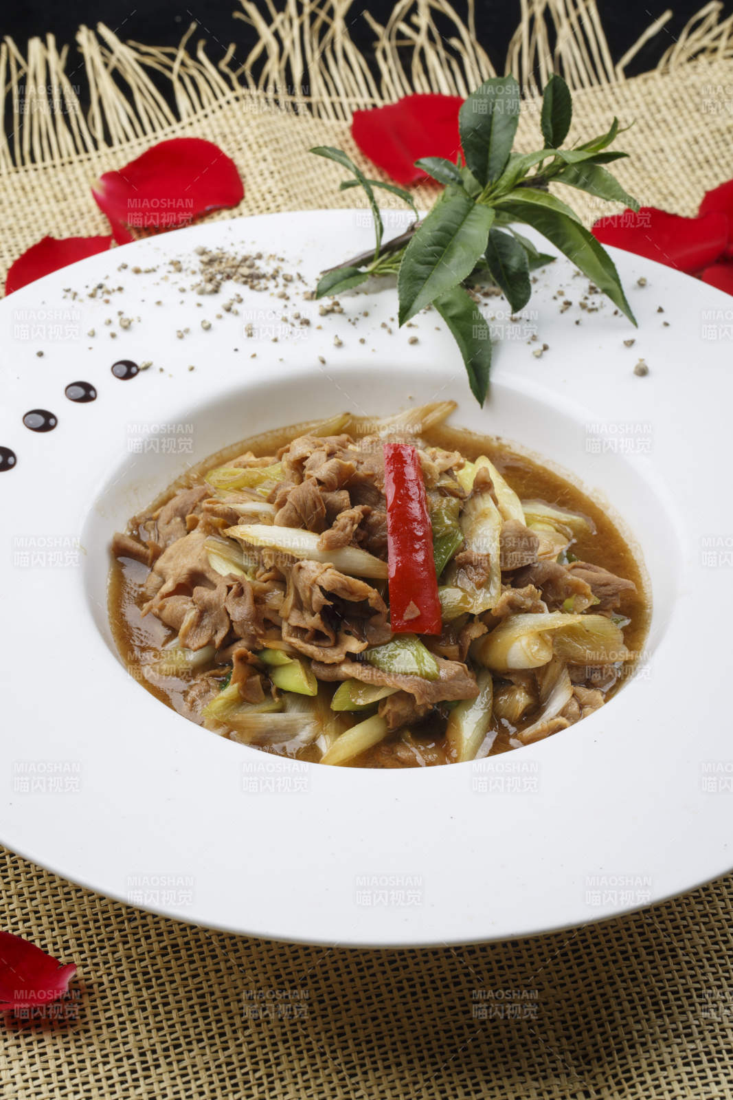 白色圆形瓷盘装的大葱爆羊肉图片