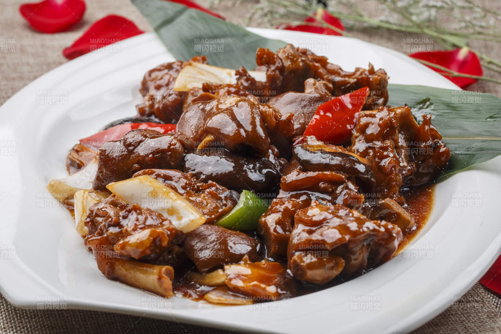 白色圆形瓷盘装的红烧香菇炖猪手猪蹄图片